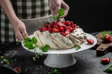Lezzetli ev yapımı Pavlova pastası taze çilek ve krem şantili. Kadın fırıncı nefis kremalı pasta dekorasyonu, üst manzara. metin için yer,