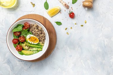 İçinde avokado, yumurta, domates, ıspanak ve ay çekirdeği olan kinoa budha kasesi. Ev yapımı yemek. Sağlıklı, temiz yemek. Vegan ya da glütensiz diyet, metin yeri, üst görünüm,