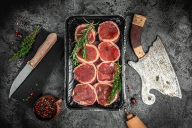 Çiğ mermer et, biftek fileminyonu. Eski et tavasında servis edilen domuz pastırmasına sarılı biftekler, yemek pişirme konsepti. Üst Manzara. metin için yer.