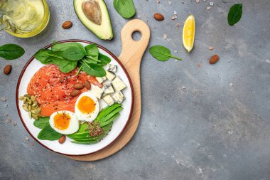 Ketogenik diyet kahvaltısı. somon, avokado, peynir, yumurta, ıspanak ve fındık. Sağlıklı yağlar, kilo vermek için temiz yiyecekler. afiş, menü, metin için tarif yeri, üst görünüm,