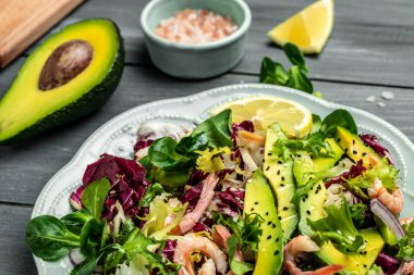 Karidesli deniz ürünleri salatası, avokado dilimleri taze yeşiller, sağlıklı yiyecekler. Süper yiyecek konsepti. Temiz yeme konsepti. Vejetaryen ya da glütensiz diyet. en üstteki görünüm.