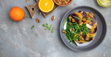 Taze pancar ve portakallı salata taze ıspanaklı vitamin salatası, peynir, fındık, kızılcık. Temiz yemek, diyet, vejetaryen yemek konsepti. en üstteki görünüm.