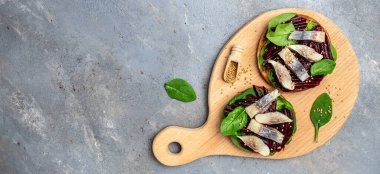 Ringa filetosu. Atlantik salamura fileto dilimli sandviç, pancar salatası, yeşil ıspanak, soğan, İskandinav mutfağı. Uzun afiş biçimi. en üstteki görünüm.