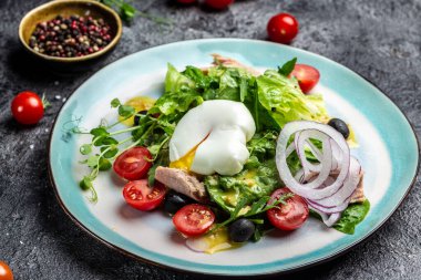 Haşlanmış ton balığı salatası, yumurta, marul, kiraz, domates zeytin ve mısır, koyu taş ya da beton arka planda. Üst Manzara. Boşluğu kopyala.