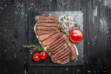 Orta pişmiş pirzola ya da biftek. Büyük bir parça fileto ile dilimlenmiş kurutulmuş ızgara biftek bifteği. afiş, menü, metin için tarif yeri, üst görünüm.