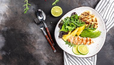 Buda kasesi, ızgara tavuk göğsü, halloumi, ananas, avokado, yeşil roket salatası, limon ve zeytinyağı. sağlıklı ve dengeli yiyecekler. afiş, metin için menü tarifi yeri, üst görünüm.