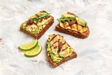 Izgara Halloumi peyniri, avokado guacamole, roka ve kızarmış ekmek. Yemek tarifi geçmişi. Kapat..