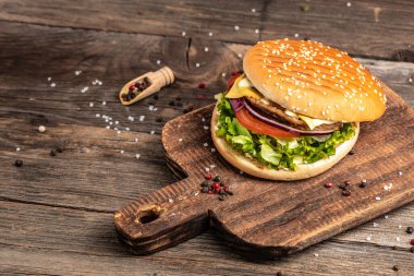 Ev yapımı hamburger, ızgara et, sebze, ahşap arka planda sos. Fast food ve abur cubur kavramı.