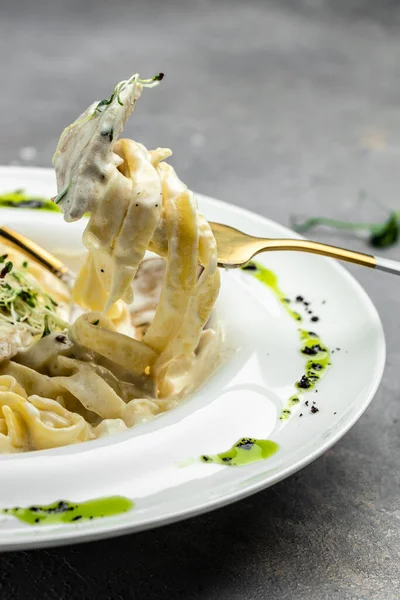 Tavuklu makarna, kremalı soslu Fettuccine Alfredo, tavuklu, parmesanlı beyaz tabak. İtalyan mutfağı. Restoran menüsü, diyet, yemek kitabı tarifi üst görünümü.