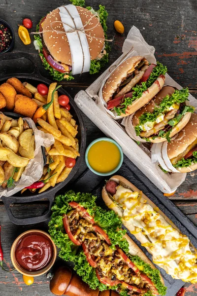 Ev yapımı lezzetli burger ve kızarmış tavuklu patates kızartması ile sosisli sandviç. Radyasyon Amerikan yemekleri. fast food. dikey görüntü. en üstteki görünüm.
