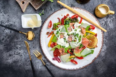 Salatanın üstüne eritilmiş peynir, füme somon, marul, güneşte kurutulmuş domates ve otlar, sağlıklı beslenme konsepti, lezzetli bir akşam yemeği.,