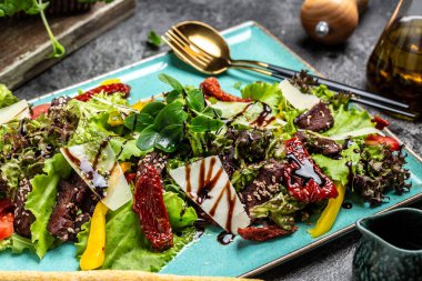 Tavuk ciğeri ve salata yaprakları, parmesan peyniri ve vişneli domates. Lezzetli dengeli gıda konsepti.