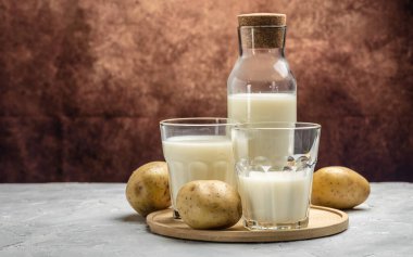 Bardakta vejetaryen patates sütü ve çiğ patates. Alternatif bitkisel süt. Süper yiyecek konsepti. Sağlıklı, temiz yemek. Vejetaryen ya da glütensiz diyet. afiş, menü, metin için tarif yeri.