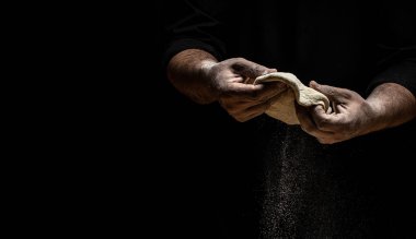 Güzel ve güçlü adamların elleri hamur yoğurur ekmek, makarna ya da pizza yapar. Tozlu un havaya karışıyor. Un bulutunun dondurucu hareketinde un taşıyan şefin elleri.