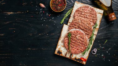 Hamburger köfteleri, hamburger için kıyma, arka planda biftek, uzun afiş formatı. en üstteki görünüm.