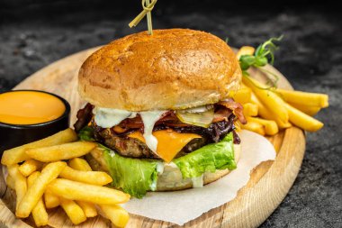 Ev yapımı hamburger, ızgara et, sebze, ahşap arka planda sos. Fast food ve abur cubur kavramı.