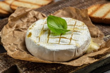 Fırında kamembert peyniri ve fesleğen yaprağı. Köy masasında ev yapımı ızgara peynir. afiş, menü, metin için tarif yeri, üst görünüm.