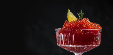 Bir kaşıkta kırmızı havyar. Siyah arka planda kase havyar. Yakın çekim somon havyar. Şarküteri. Gurme yemek. Havyar dokusu. Deniz ürünleri.