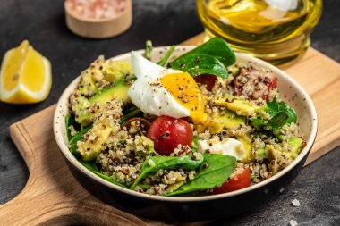 Keto diyet tabağı kinoa, avokado, yumurta, domates, ıspanak ve ay çekirdeği. Sağlıklı yiyecekler, ketojenik diyet, diyet öğle yemeği konsepti, yemek tarifi geçmişi. Kapat..