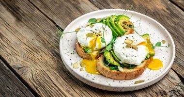 Tahta masada ıspanaklı sandviç, avokado, yumurta ve balkabağı tohumu, sağlıklı yemek, keto diyeti, diyet öğle yemeği konsepti. Uzun afiş biçimi. en üstteki görünüm.