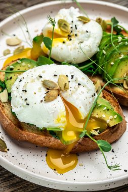 Tahta masada ıspanaklı sandviç, avokado, yumurta ve balkabağı tohumu, sağlıklı yemek, keto diyeti, diyet öğle yemeği konsepti. dikey görüntü. Üst Manzara. metin için yer.