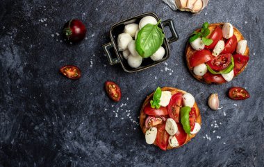 Kiraz domatesli sandviç, mini mozzarella, taze fesleğen yaprağı, ekmek üstü caprese, geleneksel İtalyan aperatifi veya aperatifi, antipasto. afiş, menü, metin için tarif yeri, üst görünüm.