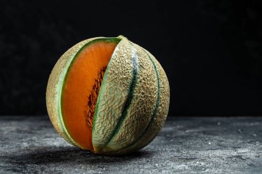 Çiğ organik Toskana kavunu kavunu. Koyu arkaplan, pano, pankart, pankart, menü, metin için tarif yeri, üst görünüm,