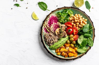 İçinde kinoa, avokado, mantar, salatalık, nohut, ıspanak, domates, avokado sebze salatası olan Buda Kasesi. Temiz beslenen vejetaryen gıda konsepti. en üstteki görünüm.