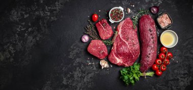 Arka planda pişmeye hazır baharatlı taze çiğ biftek seti. Uzun afiş biçimi. en üstteki görünüm.