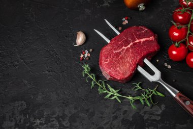 Biberiye ve baharatlı çatallı çiğ biftek. Taze biftek, restoran menüsü, diyet, yemek tarifi hazırlıyorum. metin üstü görünümü için yer.