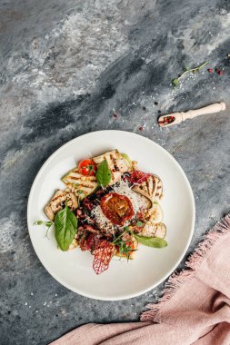 Izgara sebze, fındık, sos ve parmesanla dilimlenmiş biftek barbeküsü. İtalyan mutfağı konsepti. dikey görüntü. Üst Manzara. metin için yer.