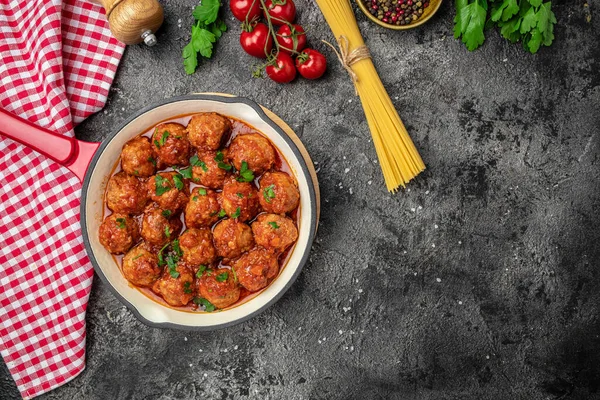 Köfteler hazır. Köfteli spagetti makarna ve siyah arka planda fesleğenli bir tavada domates sosu. afiş, menü, metin için tarif yeri, üst görünüm.