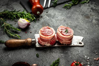 Çiğ mermer et, biftek fileminyonu. Eski kasap, aşçı ve yemek pişirme konseptinde servis edilen domuz pastırmasına sarılı madalyon biftekleri. Üst Manzara. metin için yer,