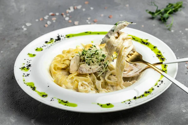 Kremalı soslu, tavuklu Fettuccine Alfredo, beyaz tabakta parmesan. Tavuk soslu makarna. İtalyan mutfağı. afiş, menü, metin için tarif yeri, üst görünüm.