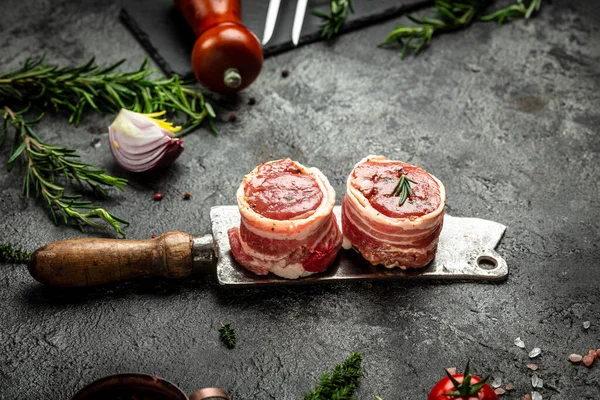 Çiğ mermer et, biftek fileminyonu. Eski kasap, aşçı ve yemek pişirme konseptinde servis edilen domuz pastırmasına sarılı madalyon biftekleri. Üst Manzara. metin için yer,