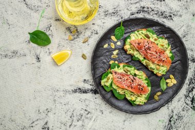 Avokadoo, somon ve ıspanak, fındık ve ayçekirdeği ile tost. Sağlıklı, temiz yemek. Vejetaryen ya da glütensiz diyet. Üst görünüm, boşluk kopyala.
