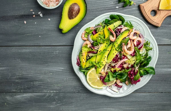 Karidesli deniz ürünleri salatası, avokado dilimleri taze yeşiller, sağlıklı yiyecekler. Süper yiyecek konsepti. Temiz yeme konsepti. Vejetaryen ya da glütensiz diyet. en üstteki görünüm.