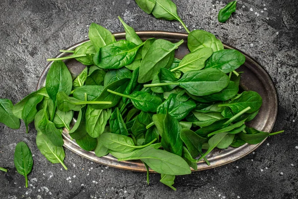 Ispanağı kapat. Çiğ organik taze ıspanak yaprakları koyu arkaplanda metal bir kasede. Yemek tarifi geçmişi, üst görünüm..