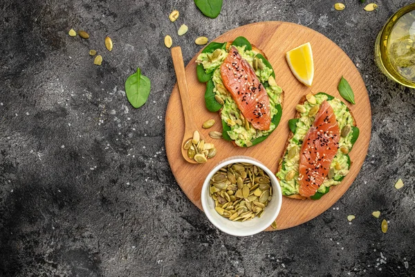 Avokado ezmeli ve somonlu tam tahıllı ekmek. Keto Paleo diyeti. Restoran menüsü, diyet, yemek kitabı tarifi üst görünümü.