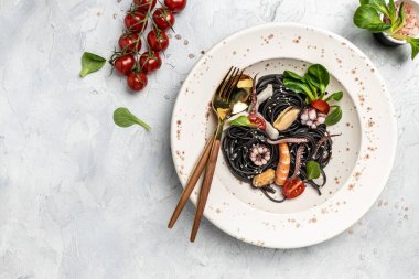 Karidesli siyah spagetti ve gri arka planda midye. Siyah spagetti. Lezzetli süper yemekler. Uzun afiş biçimi. en üstteki görünüm,