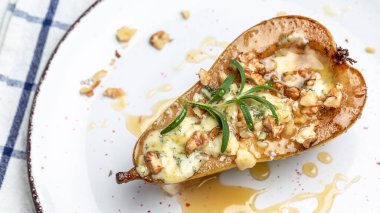 Mavi peynir, fındık ve bal ile pişirilmiş armutlar. Fransız mutfağı. Keto diyeti. Vejetaryen yemeği. Uzun afiş biçimi. en üstteki görünüm.