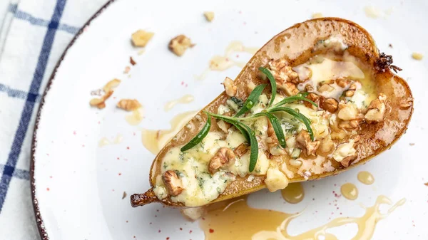 Mavi peynir, fındık ve bal ile pişirilmiş armutlar. Fransız mutfağı. Keto diyeti. Vejetaryen yemeği. Uzun afiş biçimi. en üstteki görünüm.