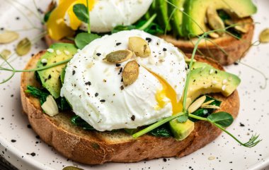 Tahta masada ıspanaklı haşlanmış yumurta, avokado ve balkabağı tohumu, sağlıklı yemek, keto diyeti, diyet öğle yemeği konsepti. Üst görünüm.
