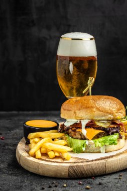 Ev yapımı hamburger, ızgara et, sebze, ahşap arka planda sos. Fast food ve abur cubur kavramı.