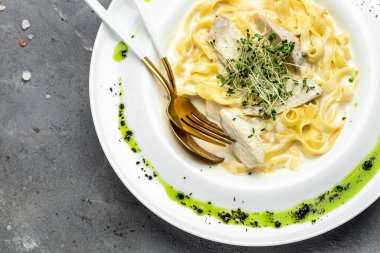 Kremalı soslu, tavuklu Fettuccine Alfredo, beyaz tabakta parmesan. Tavuk soslu makarna. İtalyan mutfağı. afiş, menü, metin için tarif yeri, üst görünüm.