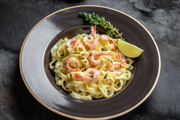 Izgara karides, beşamel sosu ve kekik soslu makarna, fettucine makarna. İtalyan yemeği. Yemek tarifi geçmişi. Kapat..