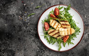 roka ve domatesli halloumi peynirli salata. Ketojenik paleo diyeti. Lezzetli kahvaltı ya da atıştırmalık, temiz yemek, diyet, vejetaryen yemek konsepti. en üstteki görünüm.