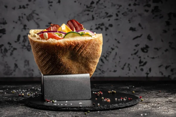 Kebap, pide, jiroskop, shaurma, sosis ile doldurulmuş sandviç ızgara et, sebze ve sosla birlikte koyu arkaplanda. afiş, menü, metin için tarif yeri, üst görünüm,