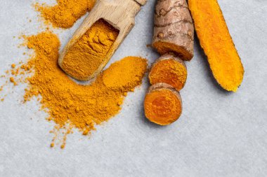 Curcuma ya da curcumin kökü. Zerdeçal tozu ve taze zerdeçal. beton arka planda. Baharat, doğal renklendirme, alternatif tıp. en üstteki görünüm.