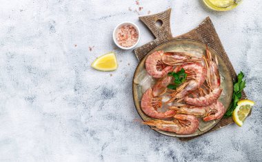 Karides, karides. Hafif arka planda buzlu deniz mahsulleri, karidesler, okyanus karidesleri. Uzun afiş biçimi. en üstteki görünüm.